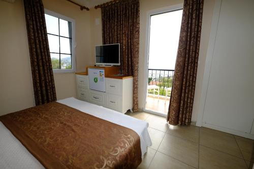 a bedroom with a bed and a tv and a window at Enda Boutique Hotel Kalkan in Kalkan