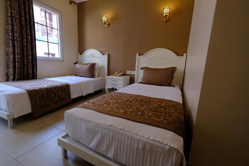 a hotel room with two beds and a window at Enda Boutique Hotel Kalkan in Kalkan