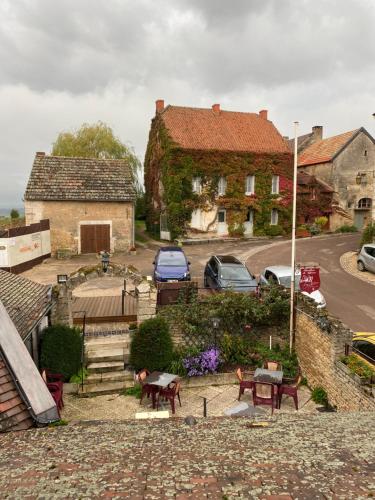a house with cars parked in a parking lot at Hostellerie Du Chateau in Châteauneuf