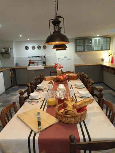 Durban-sur-ArizeにあるLa Maison Familleの長いテーブルと椅子、テーブルセットを備えた広いキッチン