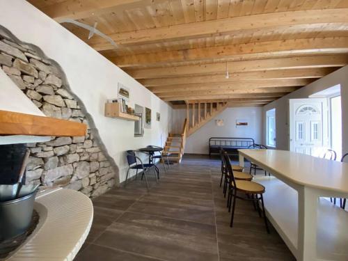 Cette chambre est dotée d'un mur en pierre, de tables et de chaises. dans l'établissement Natural Retreat Shelter #Unoblu®, 