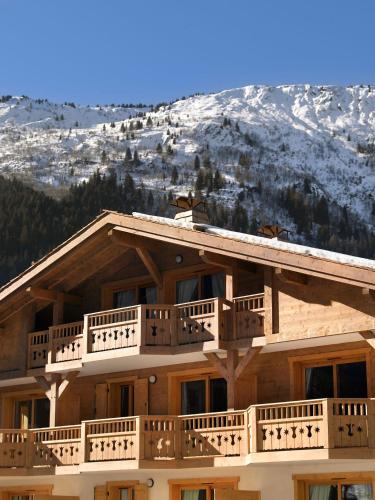 a ski lodge with a snow covered mountain in the background at CGH Résidence Boutique Le Hameau De Pierre Blanche in Les Houches