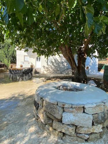 a stone wall with a tree in the middle at Natural Retreat Shelter #Unoblu® in Agriliá
