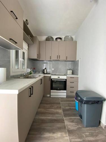 a kitchen with white cabinets and a trash can at Natural Retreat Shelter #Unoblu® in Agriliá