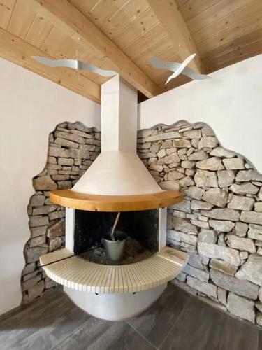 a fireplace in a room with a stone wall at Natural Retreat Shelter #Unoblu® in Agriliá