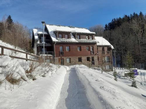 a house on a snow covered road in front at Apartmán HYGGE Bratrouchov in Jablonec nad Jizerou
