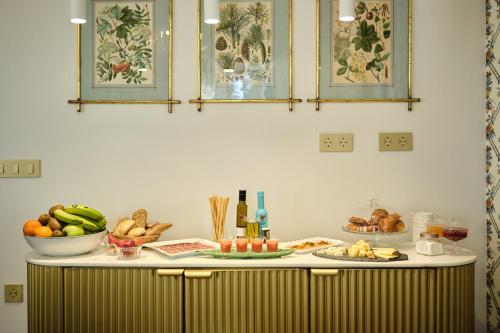 a counter with bowls of fruits and vegetables on it at HOTEL BOUTIQUE VILLA DEL MARQUÉS in Muros de Nalón