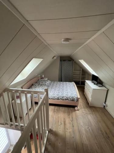 Cette chambre mansardée comprend un lit et un escalier. dans l'établissement Maison de pêcheur et son loft à 300 m de la plage, à Trévou-Tréguignec