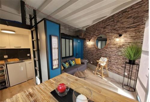 Il dispose d'une cuisine et d'un salon avec un mur en briques. dans l'établissement Maison de pêcheur et son loft à 300 m de la plage, à Trévou-Tréguignec