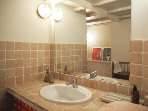 a bathroom with a sink and a mirror and a tub at La Maison Jasmin in Arles