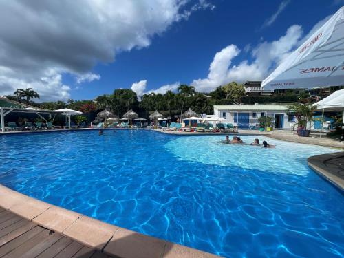 una piscina en un complejo con gente dentro en Studio spacieux vue mer au DIAMANT avec piscine, en Le Diamant