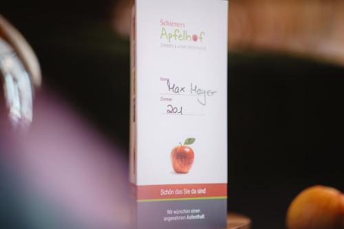 a bottle of apple juice sitting next to a peach at Schieners Hotel & Apfelhof Apartments in Wemding
