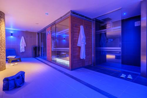 uma casa de banho com um chuveiro com iluminação azul em Hotel Sporting em Pas de la Casa