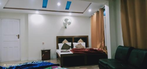 une petite chambre avec un lit et un canapé dans l'établissement Hotel Saspolo skardu, à Skardu