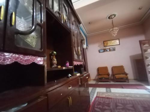 Hossam hotil في Jazīrat al ‘Awwāmīyah: غرفة معيشة مع كرسيين وتلفزيون