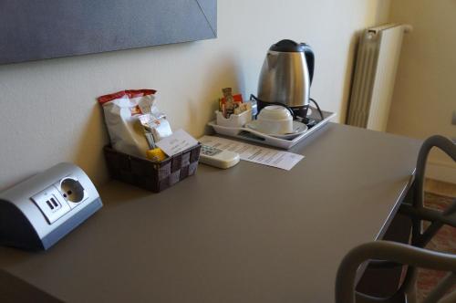 a table with a coffee maker and a box on it at Hotel La Nuova Rotaia in Gallarate