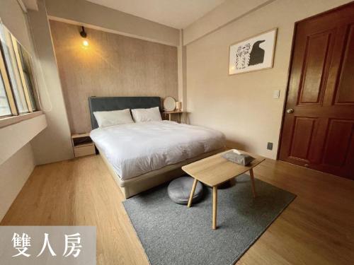 Dormitorio pequeño con cama y mesa en 度小日 en Tainan