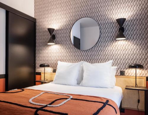 - une chambre d'hôtel avec un lit et un miroir dans l'établissement Hôtel Bristol Union Intra Muros, à Saint-Malo