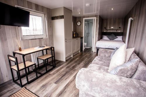 een woonkamer met een bank en een bed bij Wansbeck Riverside Caravan Park in Ashington