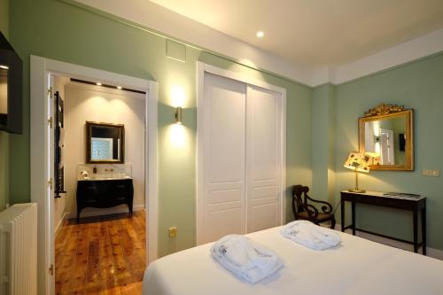a bedroom with a bed and a bathroom with a sink at HOTEL BOUTIQUE VILLA DEL MARQUÉS in Muros de Nalón