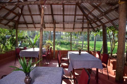 een restaurant met blauwe tafels en stoelen en bomen bij Doctors Ayurveda Heritage in Varkala