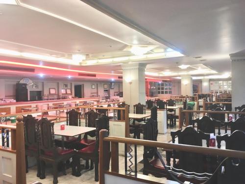 a restaurant with tables and chairs in a room at Jumbotel Hotel in Bangkok
