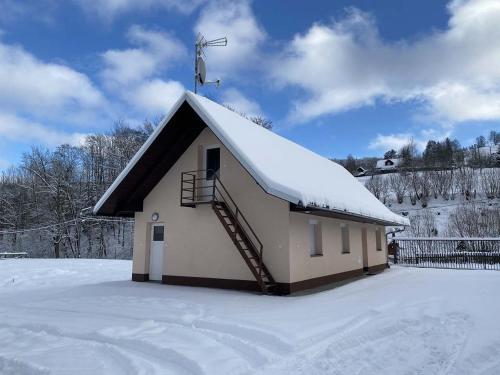 una pequeña capilla con nieve en el techo en Chalupa Juli, en Velké Karlovice