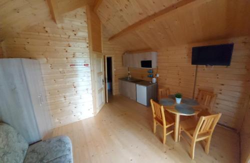 a room with a table and chairs in a cabin at Domki nad morzem Jula in Wrzosowo