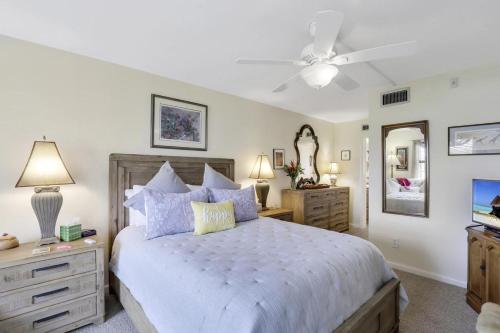 a bedroom with a bed and a ceiling fan at Island-style condo with pool, spa and steps to beach in Marco Island