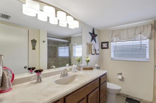 a bathroom with a sink and a toilet and a mirror at Island-style condo with pool, spa and steps to beach in Marco Island
