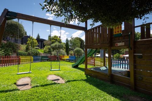 un parque infantil con columpios en el césped en Prazer da Natureza Resort & Spa, en Caminha