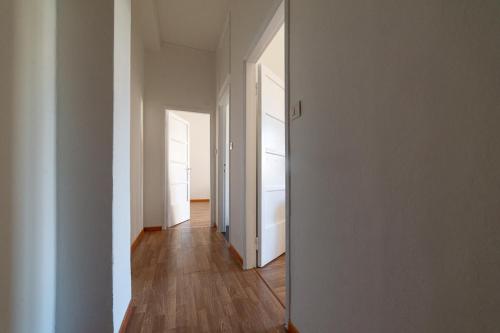 a hallway with white walls and a wooden floor at Hbhall Residenze Darsena in Milan