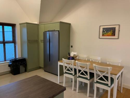 a dining room with a table and a refrigerator at Orchard Oasis, Luxury Penthouse Getaway in Coleraine