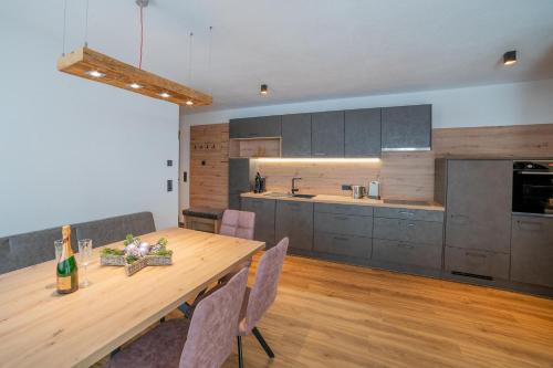 a kitchen with a wooden table and a dining room at Apartment Hoflacher in Schwendau
