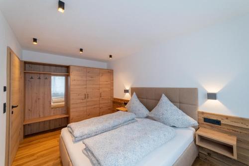 1 dormitorio con 1 cama grande y 2 almohadas en Apartment Hoflacher, en Schwendau