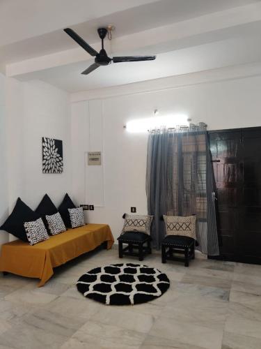 een slaapkamer met een bed en 2 stoelen en een plafondventilator bij Andoor Homes, Apt 2D in Trivandrum