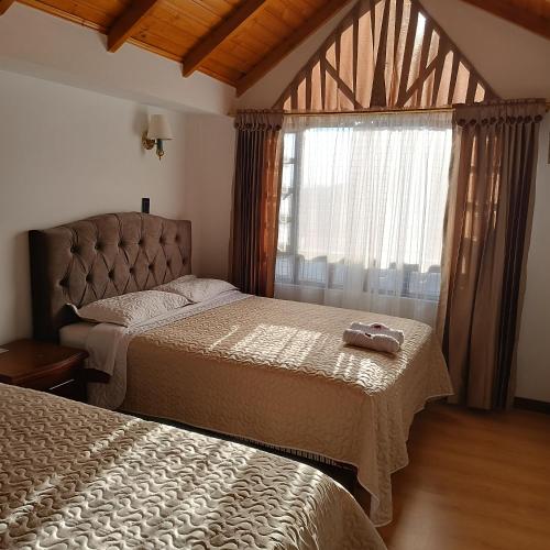 a bedroom with two beds and a window at Villa Graciela I in Paipa