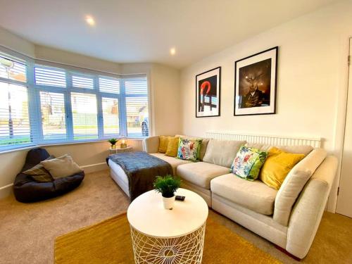 a living room with a couch and a table at Spacious 3 Bedroom House - 5 Minutes to the nearest Beach! - Great Location - Garden - Parking - Fast WiFi - Smart TV - Newly decorated - sleeps up to 7! Close to Poole & Bournemouth & Sandbanks in Lytchett Minster