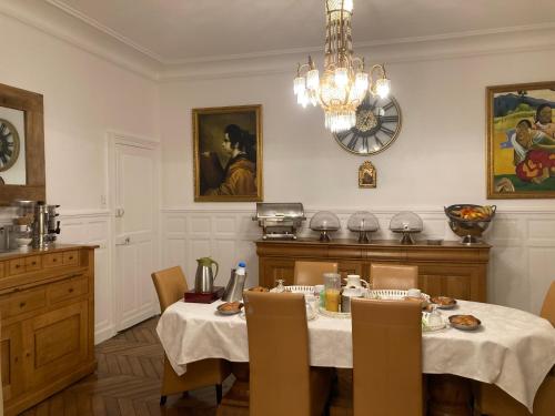 a dining room with a table and a clock on the wall at Casa La Palma Le 48 in Soissons