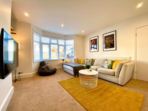 a living room with a couch and a tv at Spacious 3 Bedroom House - 5 Minutes to the nearest Beach! - Great Location - Garden - Parking - Fast WiFi - Smart TV - Newly decorated - sleeps up to 7! Close to Poole & Bournemouth & Sandbanks in Lytchett Minster