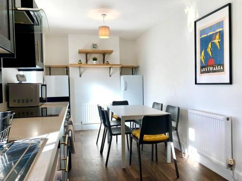 a kitchen with a table and chairs in a room at Spacious 3 Bedroom House - 5 Minutes to the nearest Beach! - Great Location - Garden - Parking - Fast WiFi - Smart TV - Newly decorated - sleeps up to 7! Close to Poole & Bournemouth & Sandbanks in Lytchett Minster
