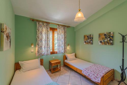 two beds in a room with green walls at Villa Melina 2 in Koinyra