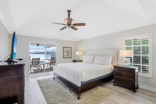 Un dormitorio con una cama y un ventilador de techo. en Waterfront home with spectacular view, pool and spa, en Marco Island