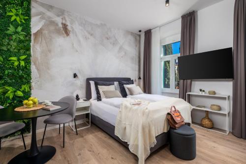 Schlafzimmer mit einem Bett, einem Tisch und Stühlen in der Unterkunft Molo Longo - Central Apartments & Rooms in Rijeka