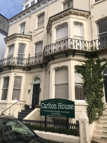 a sign in front of a building with a caution house at Carlton House Guesthouse in Scarborough
