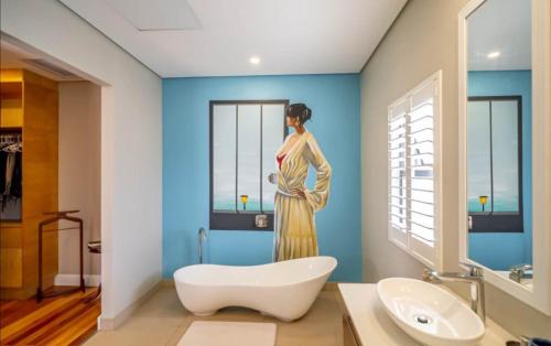 a bathroom with a painting of a woman on the wall at Stephen's guest house in Richards Bay