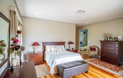 a bedroom with a large bed and a dresser at Stephen's guest house in Richards Bay