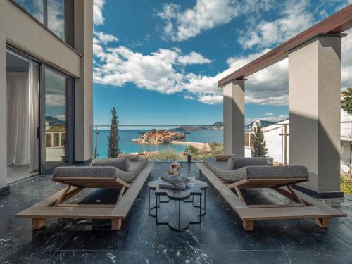 a patio with two couches and a table at Villa Geba Boutique Hotel in Sveti Stefan