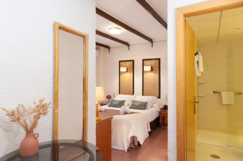 a bedroom with a bed and a bathroom with a shower at Hotel Eden Mar in Guardamar del Segura