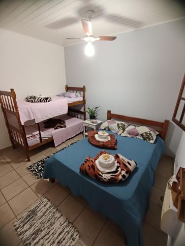 a room with two beds and a table with food on it at Suítes da Val in Paraty